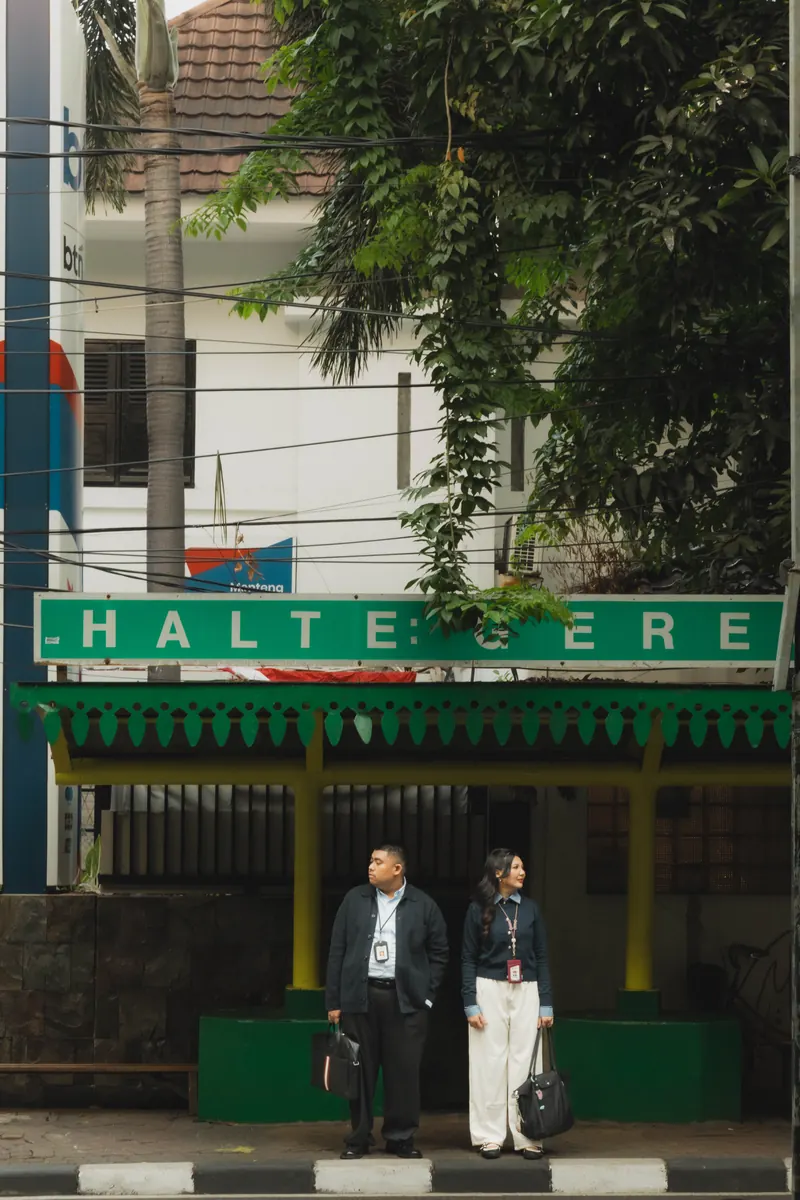 Rafli dan Dita menunggu di halte beratap hijau