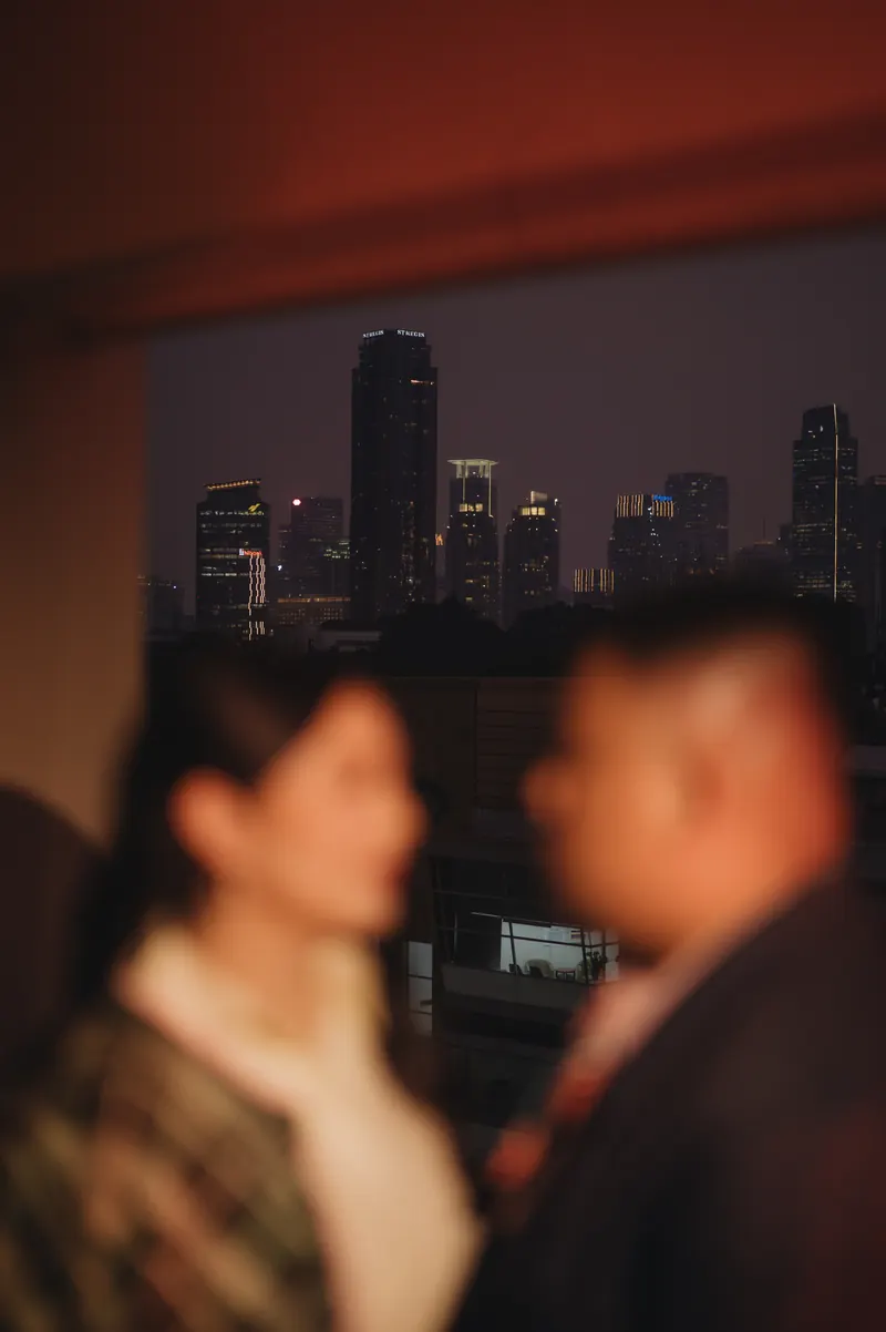 Rafli dan Dita berhadapan dalam fokus lembut, lampu kota malam di belakang mereka