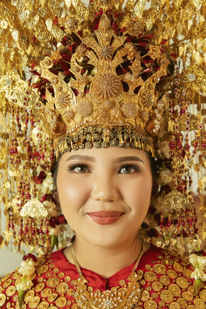 Dita tersenyum di bawah mahkota Palembang yang tinggi keemasan