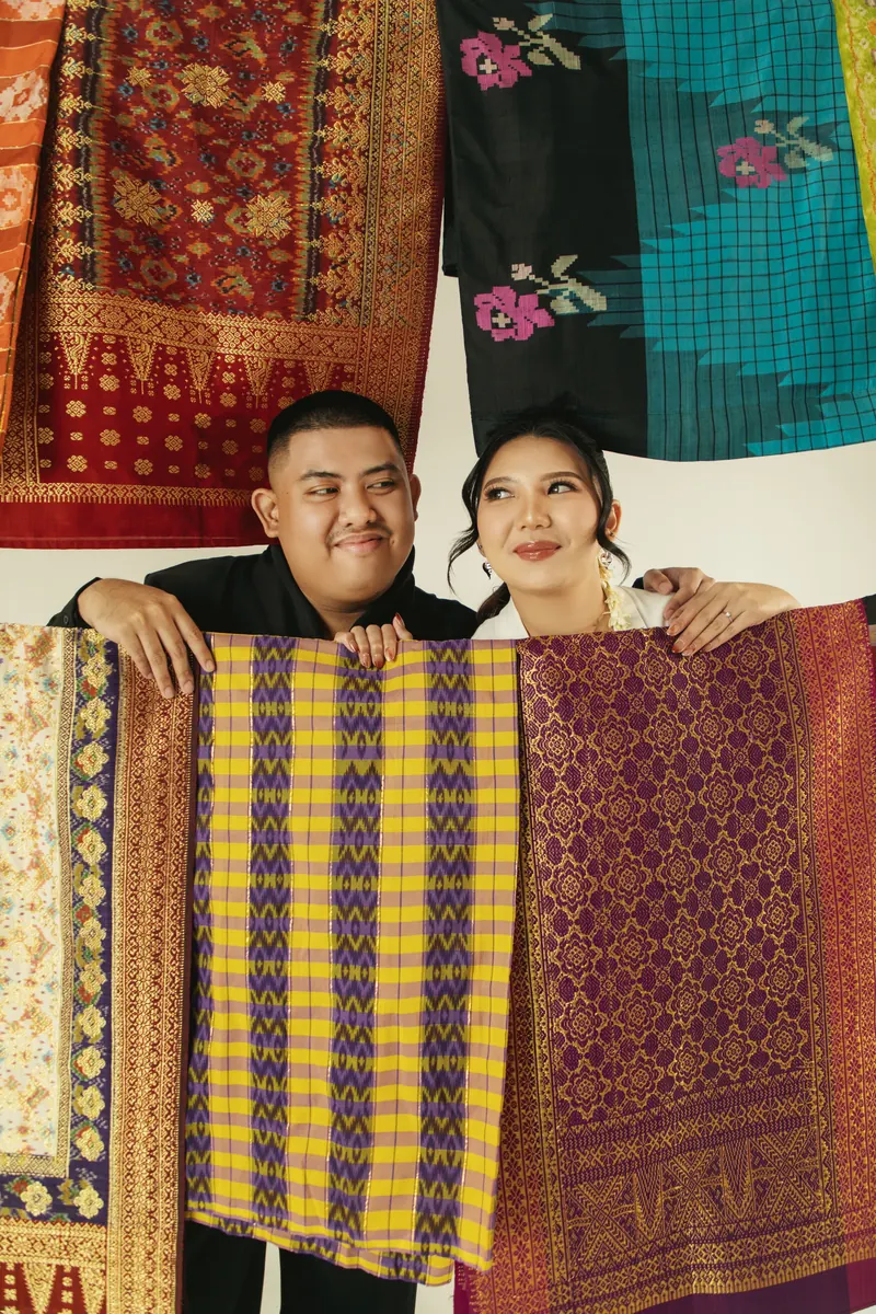 Rafli dan Dita membentangkan songket bergaris di antara mereka